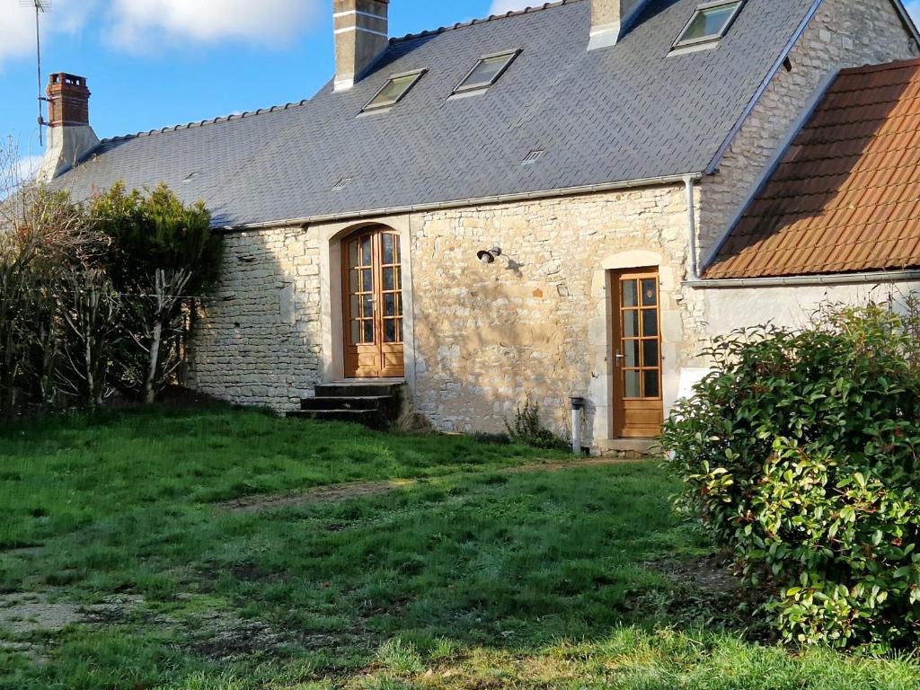 an old stone house with a gambrel roof at Gite les Frênes avec pré dans joli hameau in Vermenton