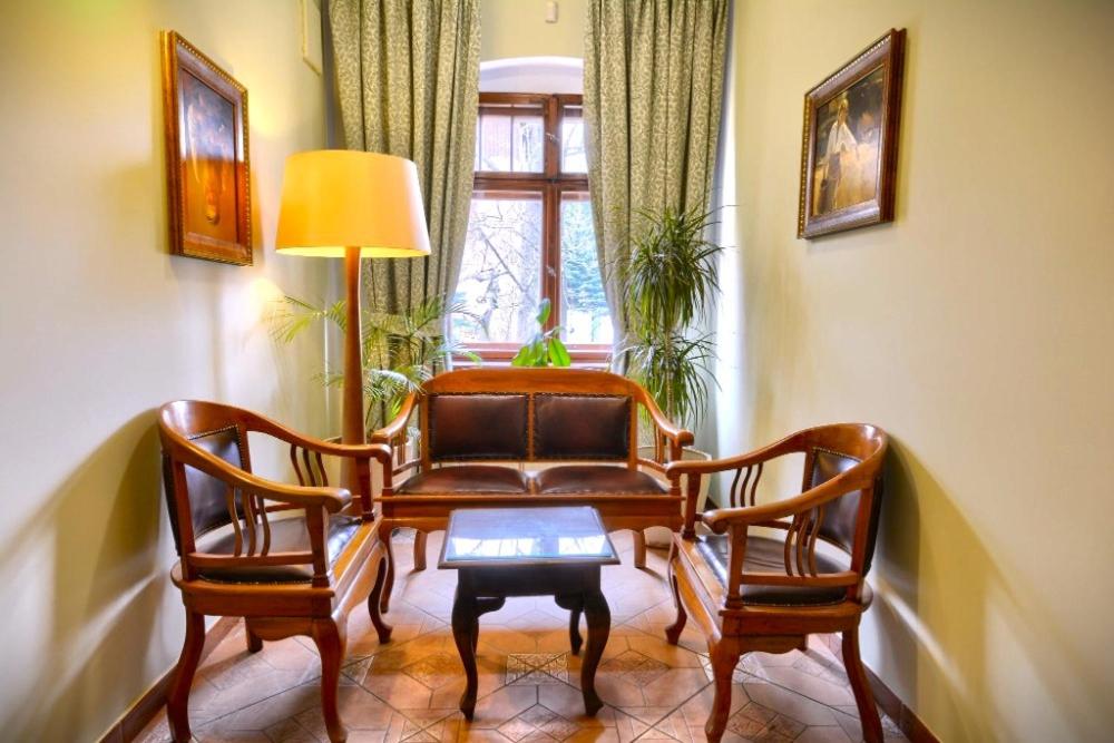 Rezydencja Trojan Karpacz في كارباش: غرفة معيشة مع أريكة وكرسيين