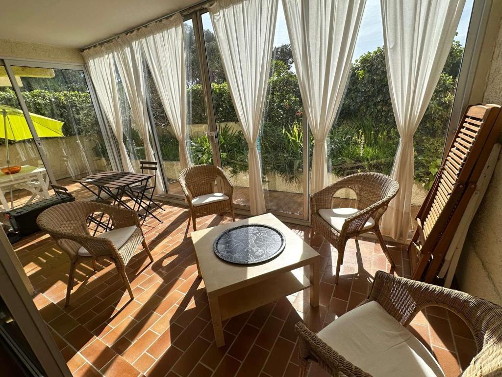 - une véranda avec des chaises et une table dans l'établissement Grand T2 avec loggia et terrasse à proximité du port de Saint Mandrier et des plages, à Saint-Mandrier-sur-Mer