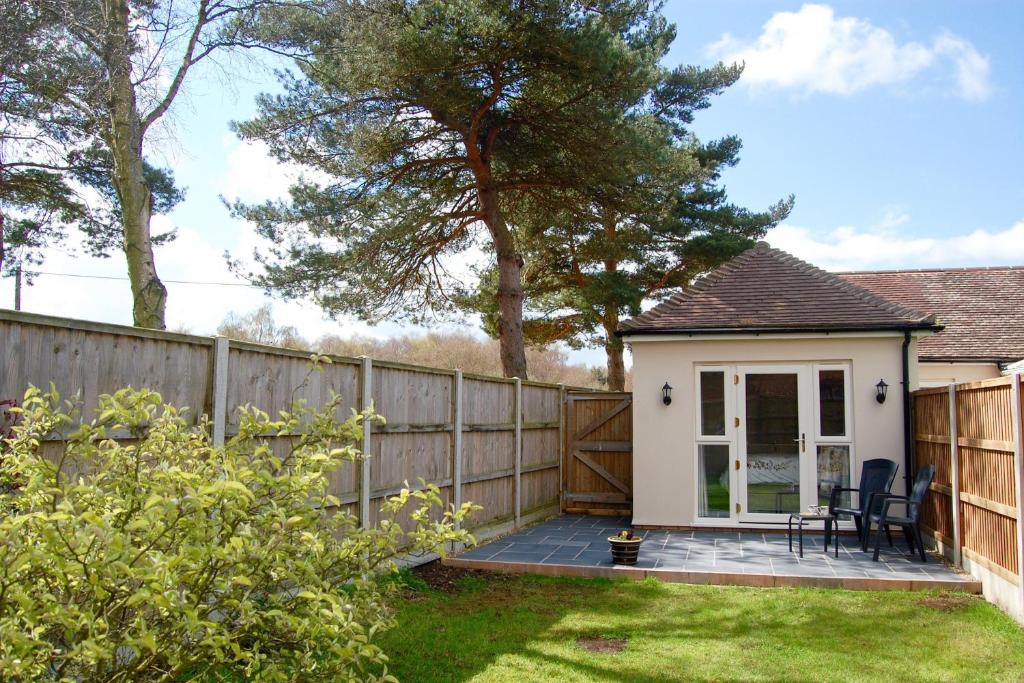une maison avec une clôture et une terrasse dans l'établissement Little Birches, à Grimston