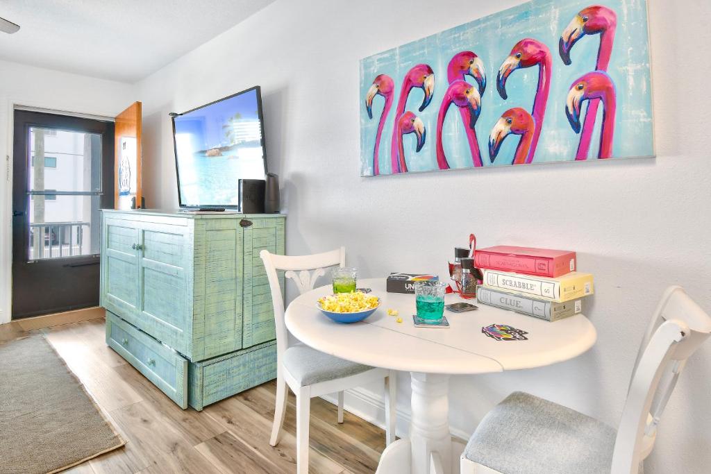 una habitación con una mesa y una pintura de flamencos en Funshine Sunset Beach, en St Pete Beach