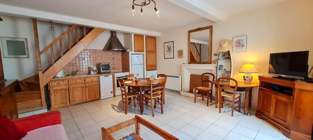 une cuisine et une salle à manger avec une table et des chaises dans l'établissement Petite maison de village au cœur du village, à Saint-Clément-des-Baleines