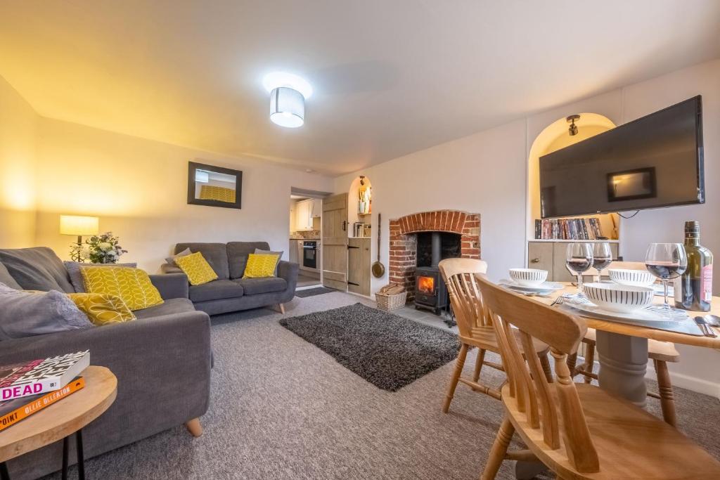 a living room with a couch and a table at Lovely Cottage in North Creake