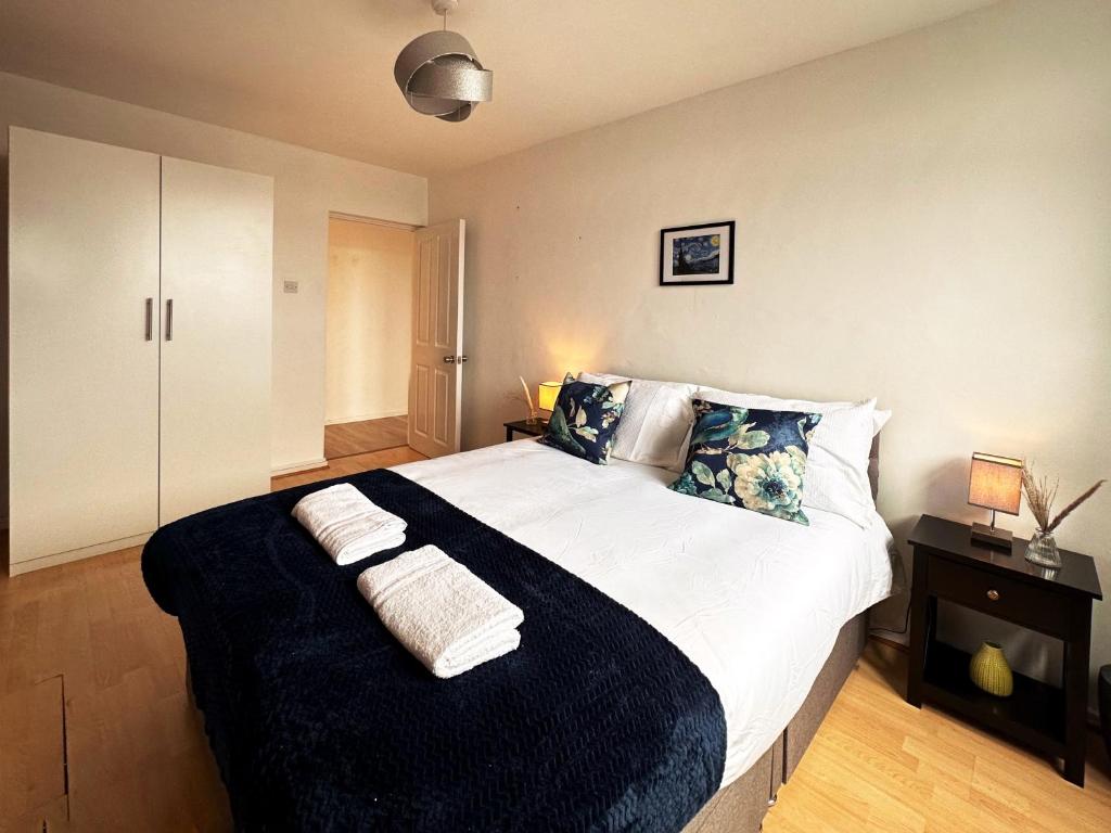 um quarto com uma cama grande com duas toalhas em Penny's Place in Grove Park em Eltham