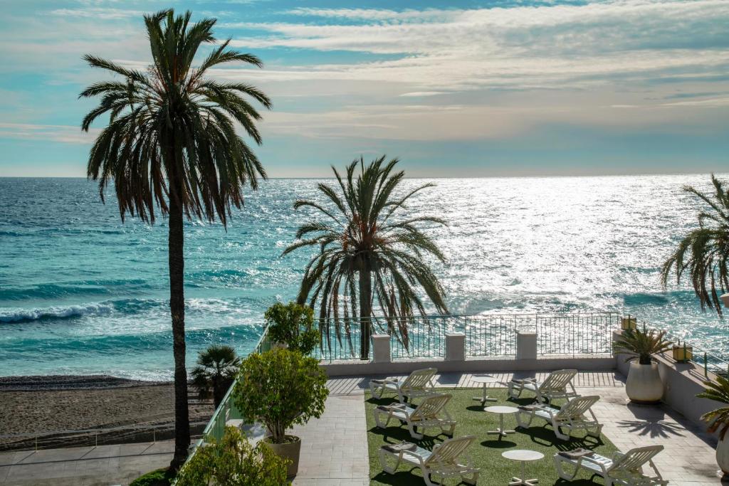 a view of the ocean from the balcony of a resort at Hôtel Vendôme Menton in Menton