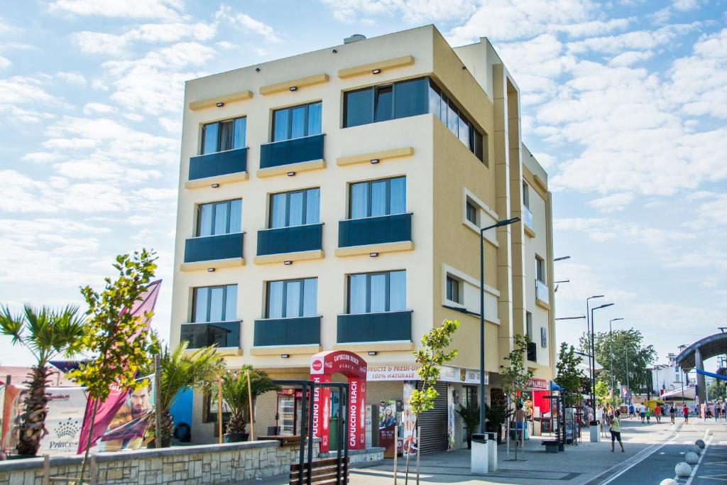 a tall yellow building on a city street at Sara Boutique Hotel - Laurette Due in Mamaia