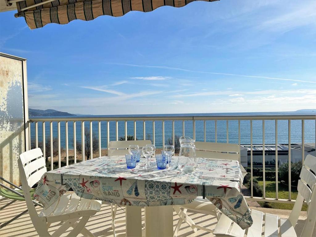 una mesa en un balcón con vistas al océano en Appartement Le Lavandou, 1 pièce, 3 personnes - FR-1-251-252, en Le Lavandou