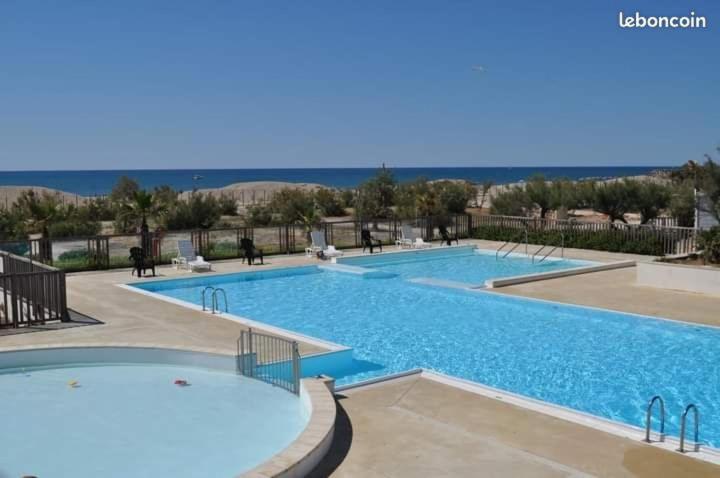 a large swimming pool with blue water at mobil home in Palavas-les-Flots