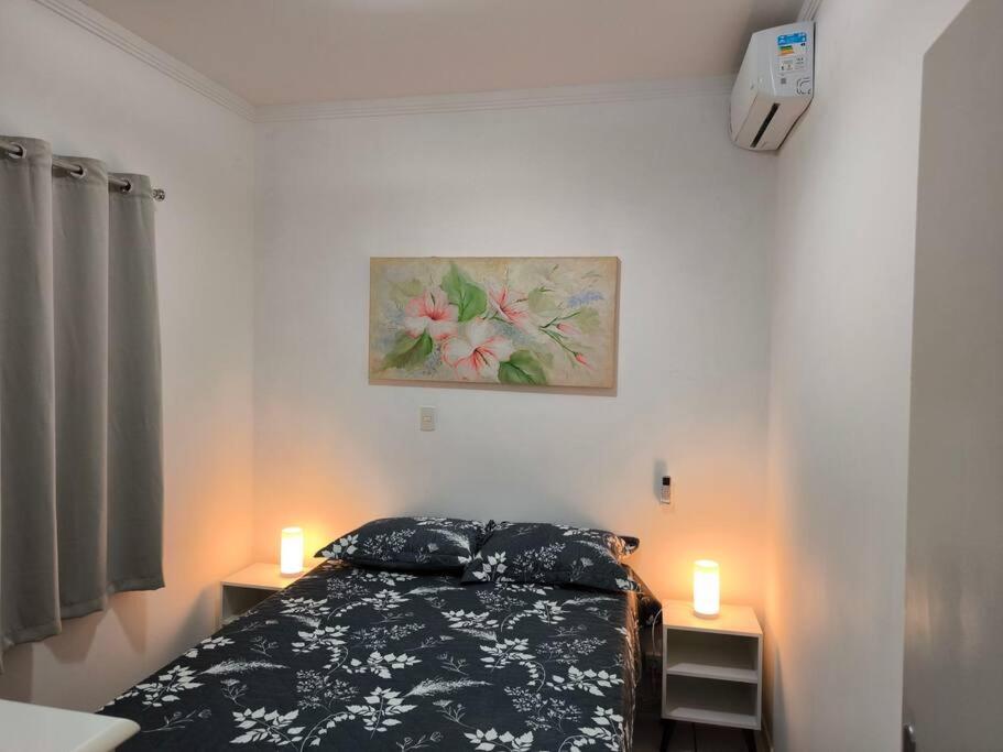 a bedroom with a bed with two candles on it at Seu cantinho em Águas in Águas de Lindóia