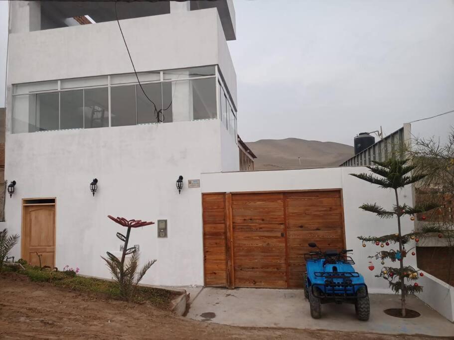 un volant bleu garé devant une maison dans l'établissement Villa Alfonso - Casa playa con piscina temperada, à Lima