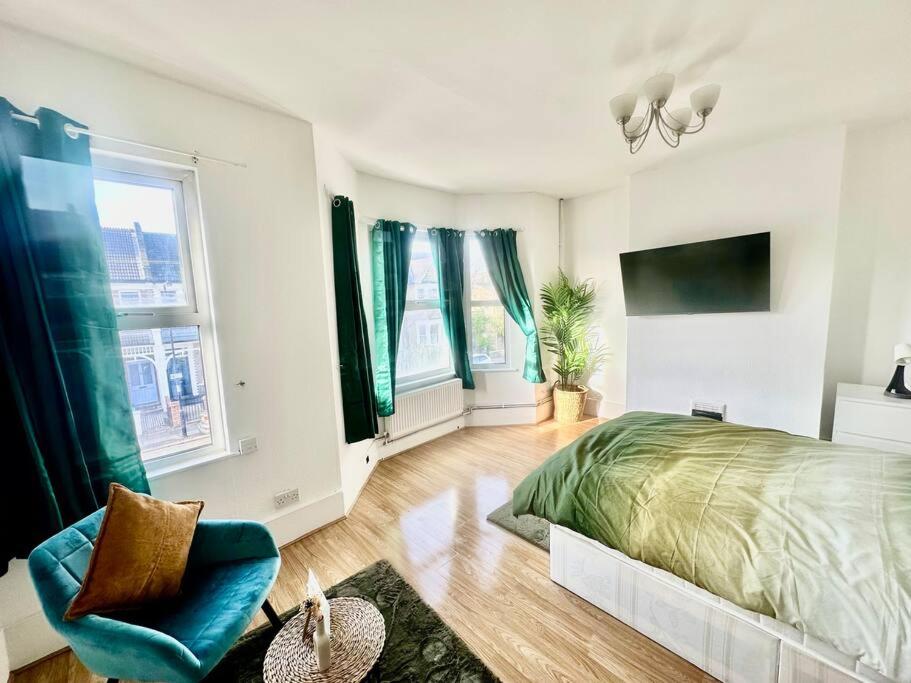 1 dormitorio con 1 cama, 1 silla y ventanas en Cosy two bedroom apartment,SE13, en Londres