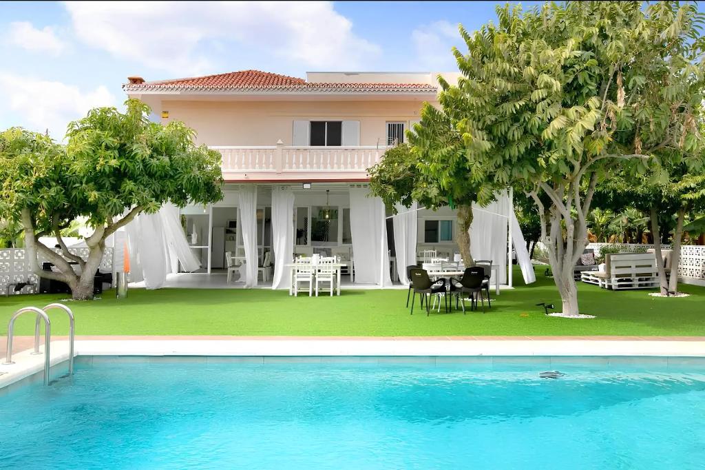 Villa con piscina frente a una casa en Tropical Oasis Villa Playa Paraiso, en Playa Paraiso