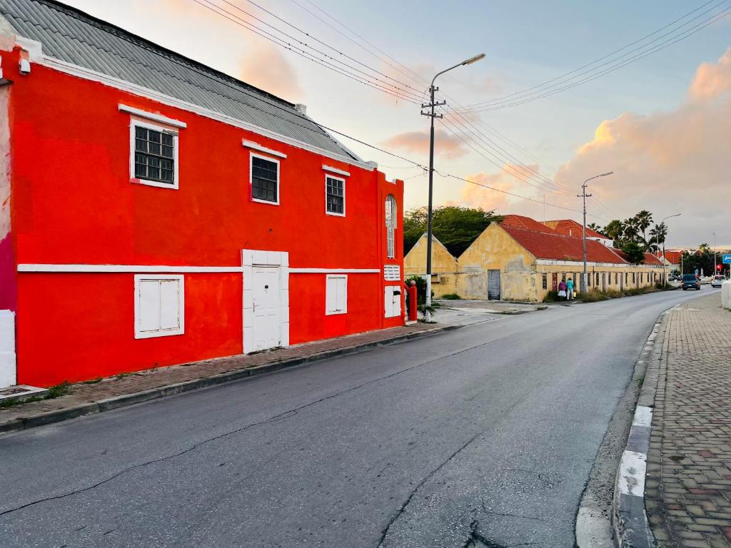 un edificio rojo al lado de una calle en Nouvelle Orange Willemstad, en Willemstad