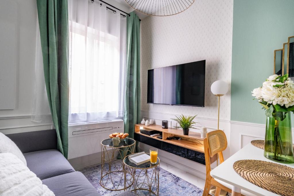 un salon avec un canapé et une télévision dans l'établissement Écrin de Verdure : Confort et Modernité, à Avignon