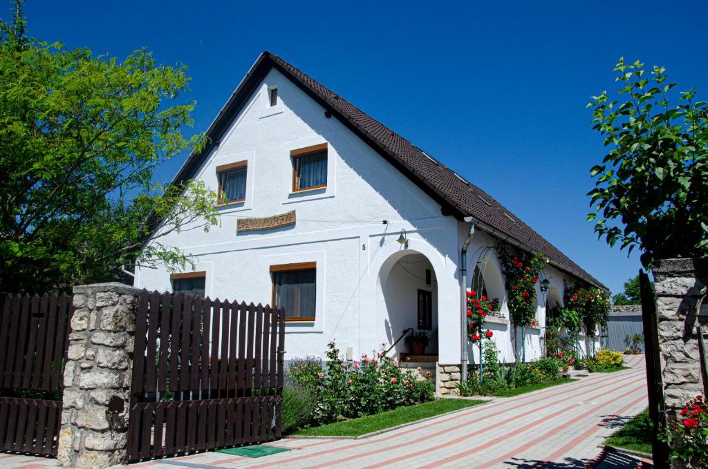 una casa blanca con techo negro y valla en Bánóporta, en Köveskál