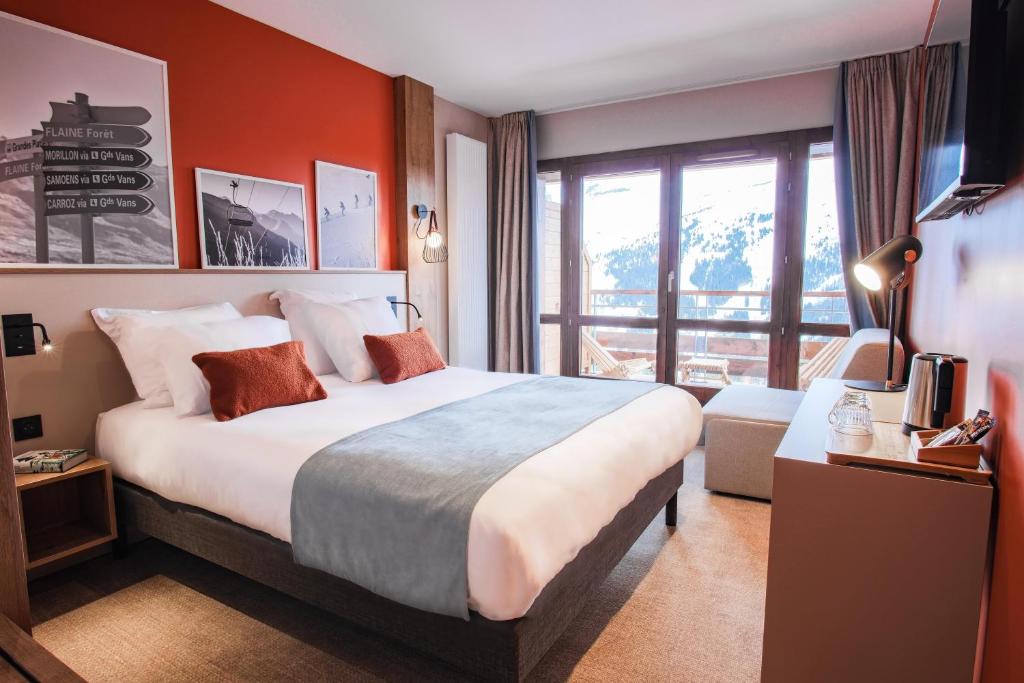 a hotel room with a large bed and a balcony at Belambra Clubs Flaine Panorama in Flaine