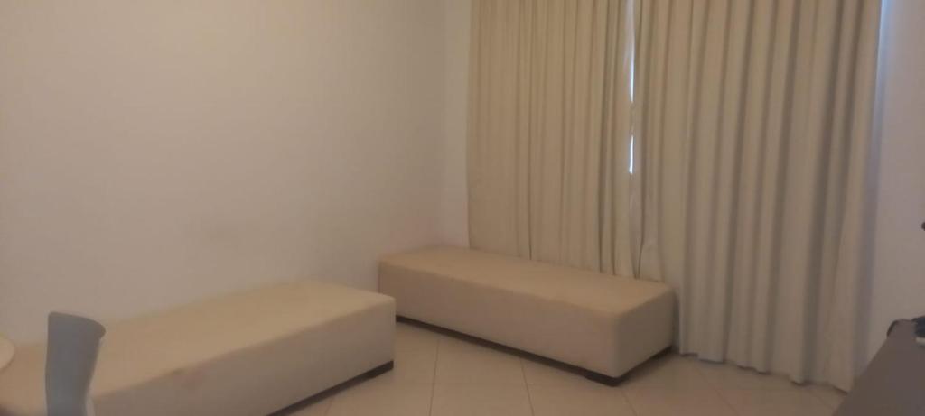 a white room with a couch and a stool at Condominio Barretos Thermas Park apto 312 in Barretos