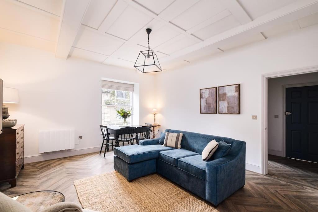 a living room with a blue couch and a table at Great Escapes Oundle Flat 3 in Oundle