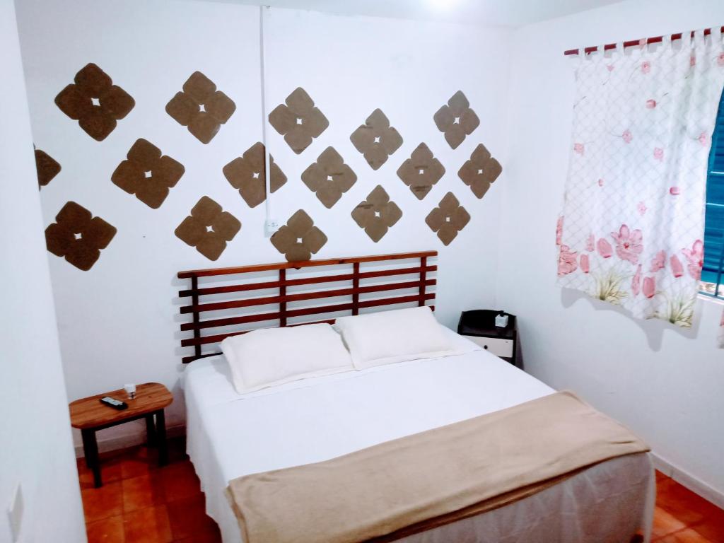 a bedroom with a white bed with a wooden headboard at Rancho do Edy Pousada in São Roque