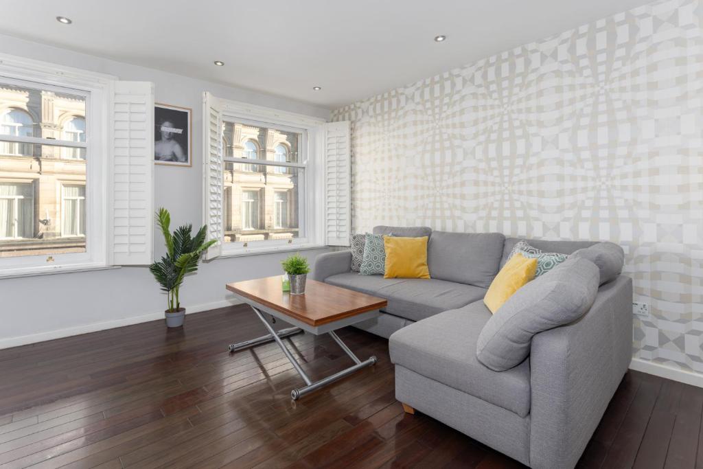 a living room with a couch and a table at Flatzy - 3 Bedroom Apartment in Heart of City Centre in Liverpool
