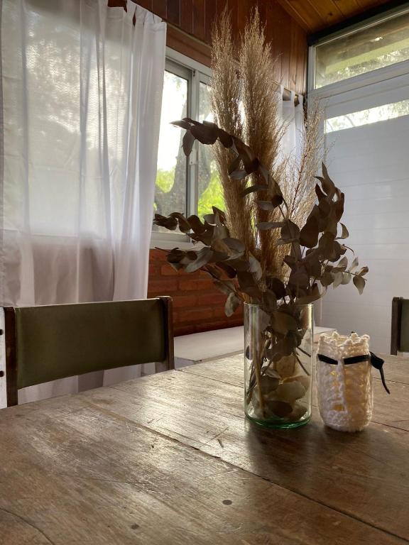 un jarrón de flores sentado en una mesa de madera en Casa de Campo Tierra de ensueños in 