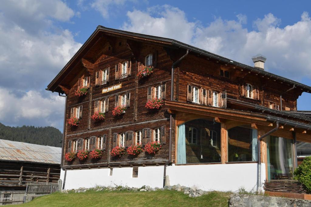 ein Holzhaus mit Blumenkästen an den Fenstern in der Unterkunft Casa Fausta Capaul in Brigels