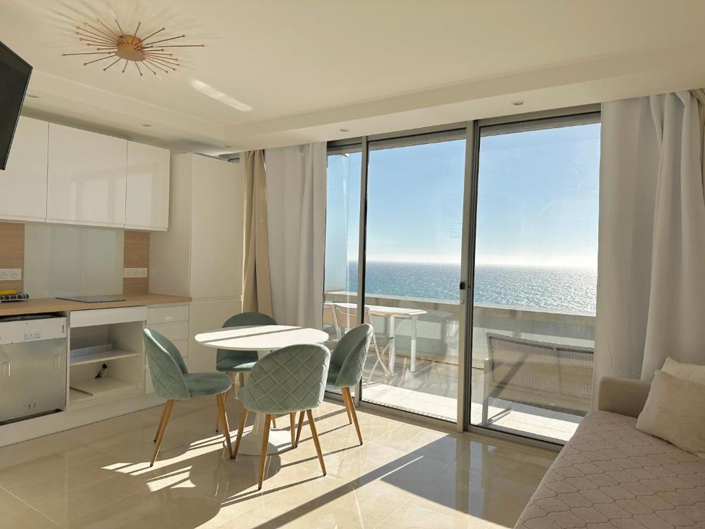 カップ・ダイユにあるRIVIERA Appart'hôtel Panoramiqueのキッチン、海の景色を望むダイニングルーム