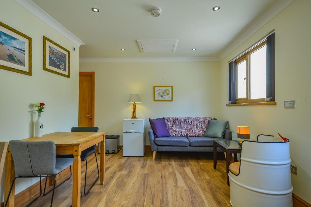 a living room with a table and a couch at Cosy Cabin Perfect To Explore in Garnant