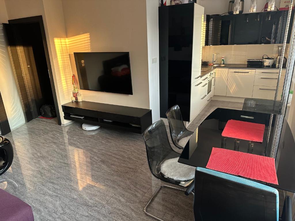 a living room with a television and a table and chairs at Sunny modern apartment with 2 rooms with a view and good connections to the centre in Prague