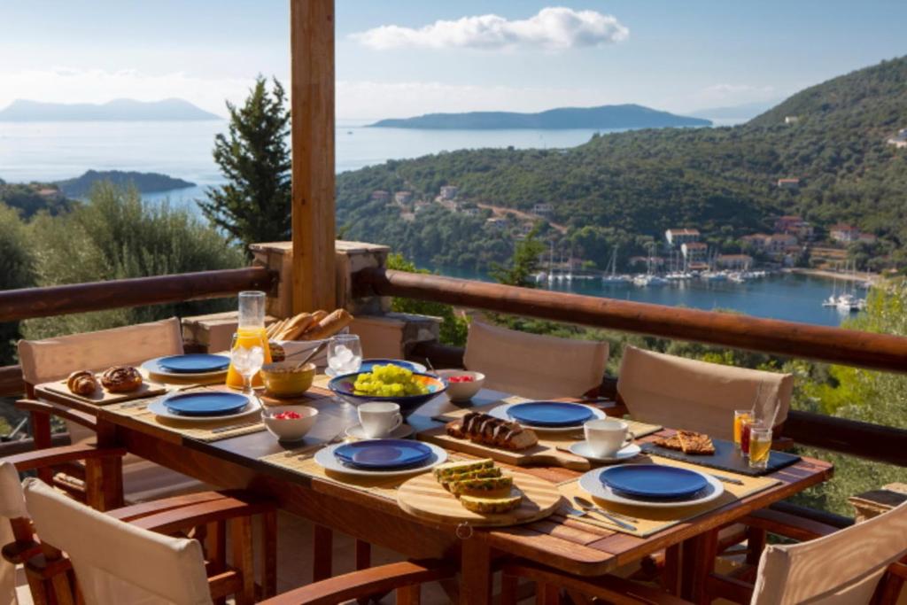 a wooden table with food on top of a balcony at Villa Giancarlo - Lovely Villa with Stone and Wood Elements in Sivota Bay in Sivota