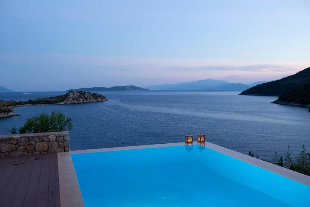 シヴォタにあるVilla Kalamos - Modern Villa in Sivota Bay with Direct Access to Seaの水辺の景色を望むスイミングプール
