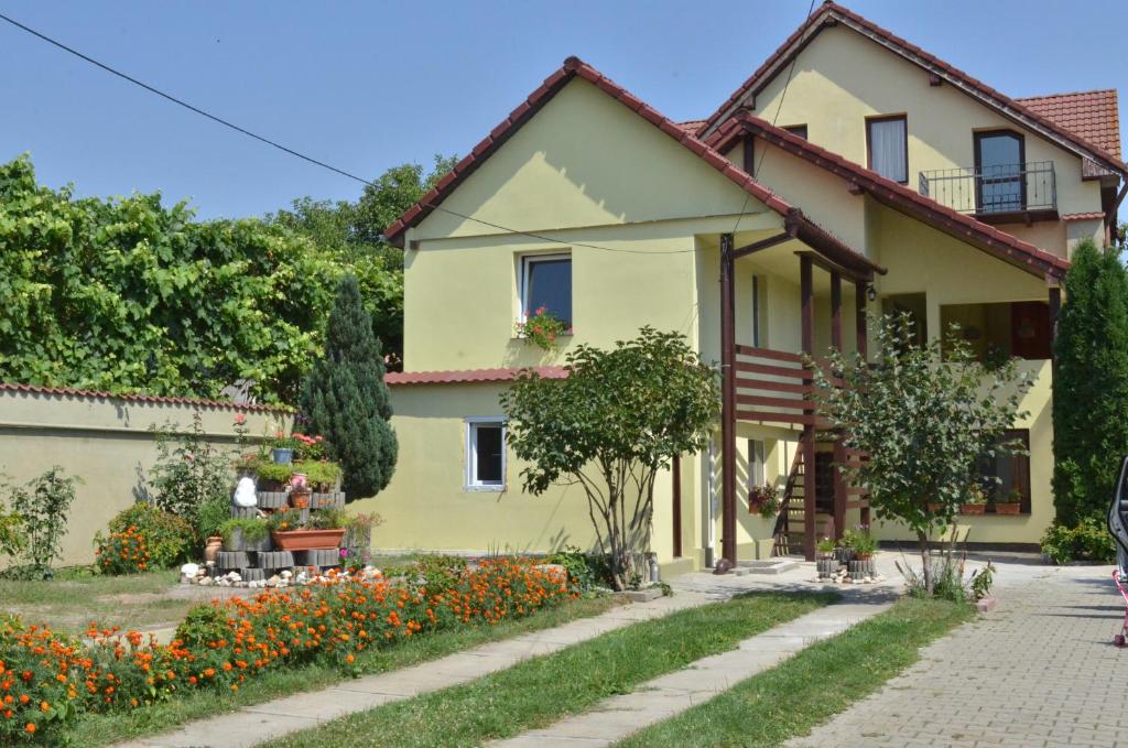 a yellow house with flowers in front of it at Vila Bel Ami in Şelimbăr