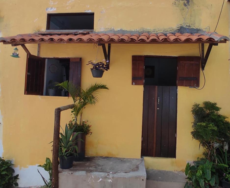 Casa amarilla con puerta y ventanas marrones en Meu Cantinho Aconchegante Lençóis, en Lençóis