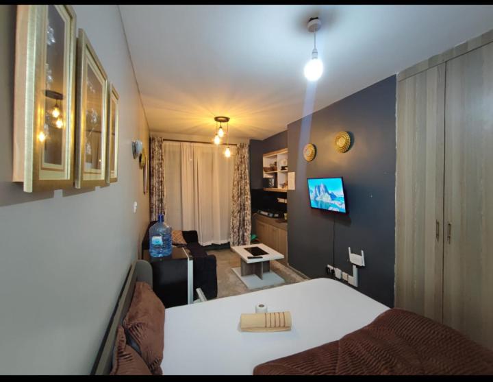 - une chambre avec un lit et un salon dans l'établissement Tsavo Royal Suburbs, à Nairobi