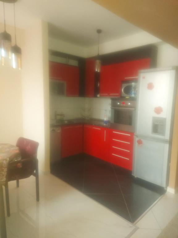 a kitchen with red cabinets and a white refrigerator at Hana's Luxury apartment in Skopje