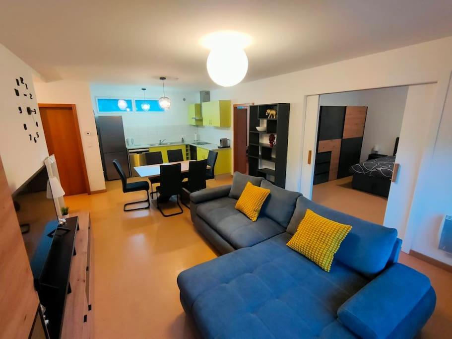 een woonkamer met een blauwe bank en gele kussens bij Industriel F3 Appartement in Thann