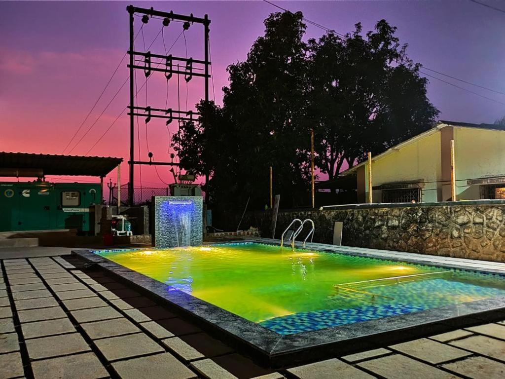 una piscina con luci colorate in un edificio di HOTEL NATURE SHIELD a Lonavala