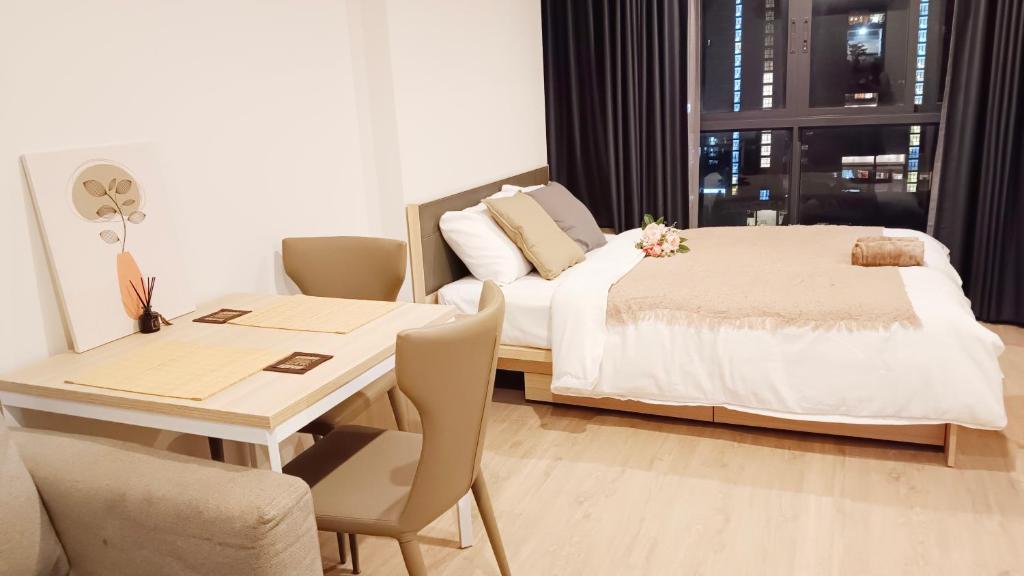 ein Schlafzimmer mit einem Bett und einem Tisch sowie ein Esszimmer in der Unterkunft Ideo O2 Cozy BTS Bangna in Bangkok