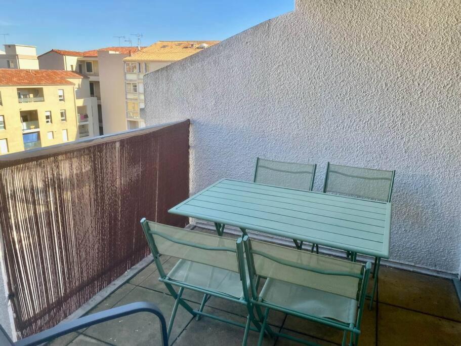 niebieski stół i 2 krzesła na balkonie w obiekcie ''Ophélia 84'' Duplex en centre ville avec parking w mieście Sète