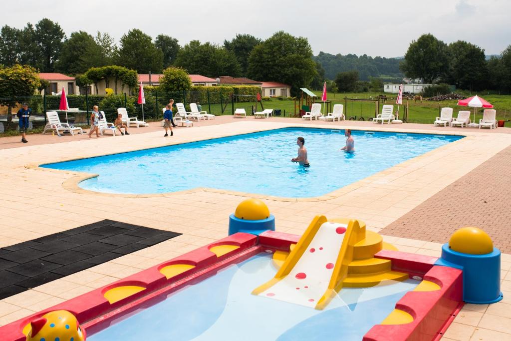 a swimming pool with people playing in the water at Camping la Colline in Virton