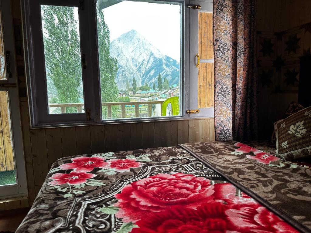 Kanzalwan的住宿－D’SHIEKHS RESORT GUREZ，窗前的一张床上有红色花朵