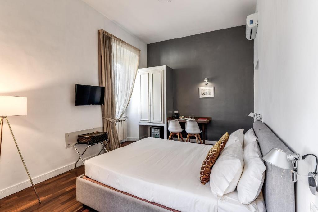 a bedroom with a large white bed and a table at Little Queen Relais in Rome