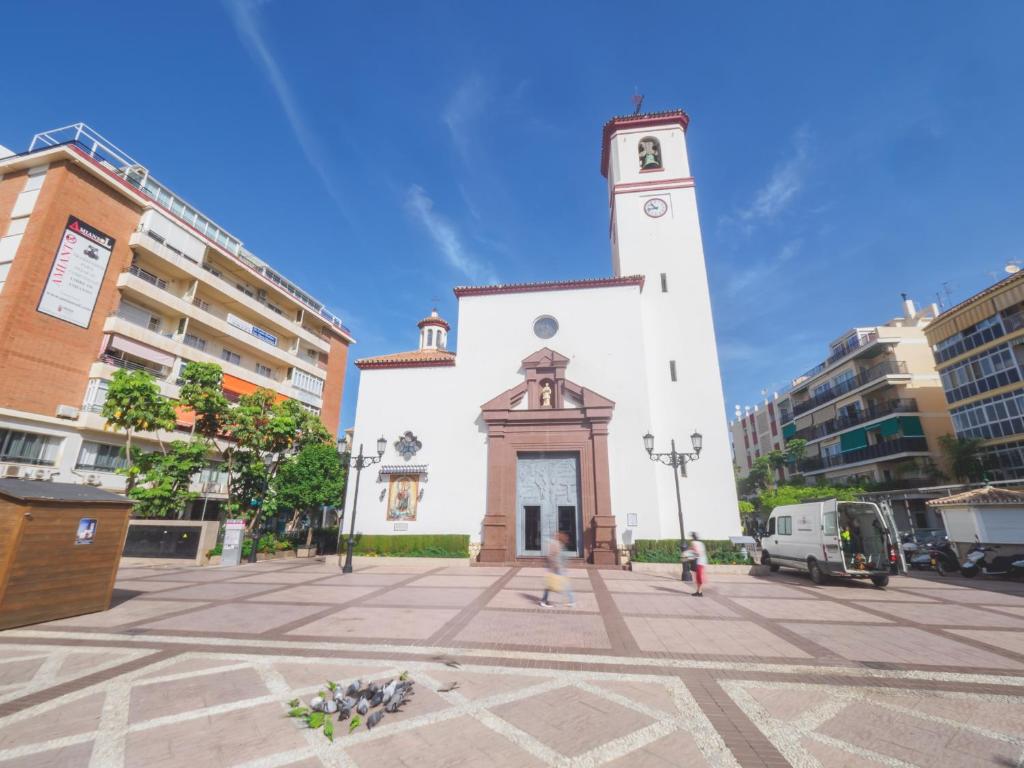 フエンヒロラにあるCubo's Apartamento España 2C Fuengirolaの通りの真ん中にある時計塔のある建物