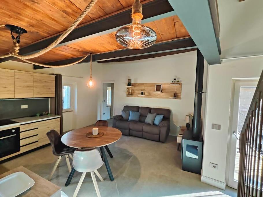 a living room with a table and a couch at Volaterrae Deluxe Loft with garden in Volterra