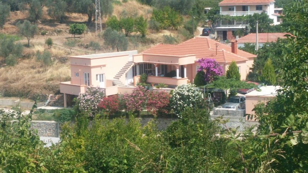 a house on a hill with flowers in front of it at Guest's house ''Lindi&Roni'' in Ulcinj