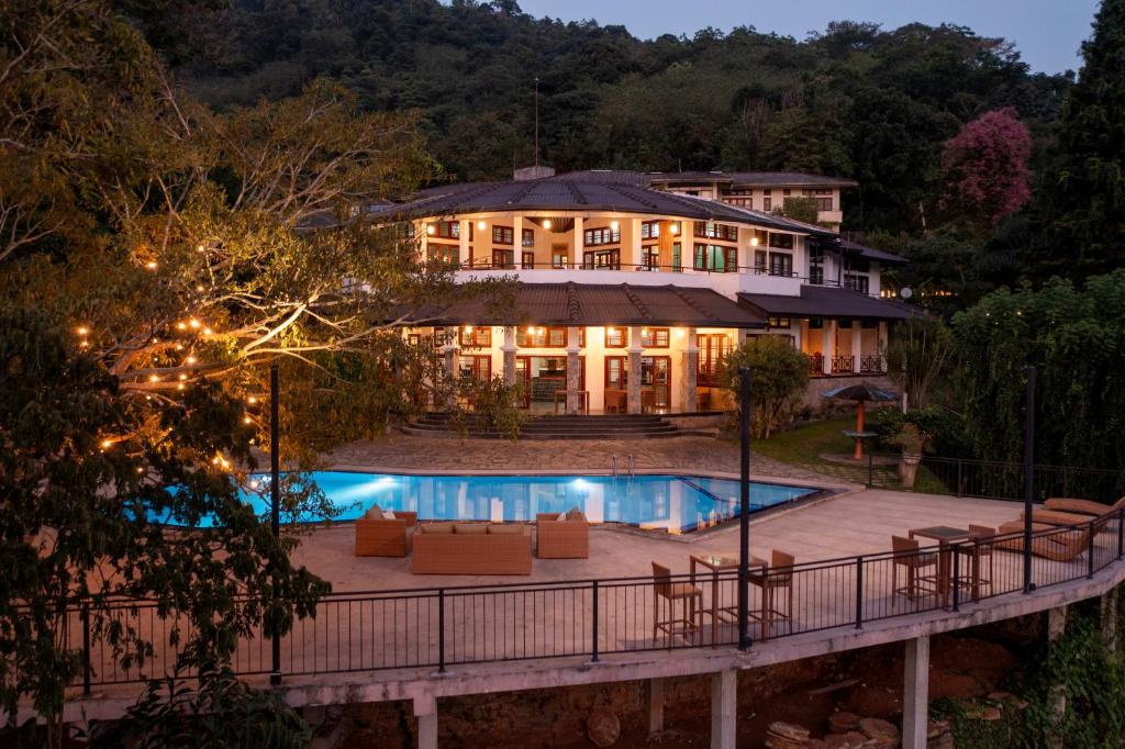 a large house with a swimming pool in front of it at Indra Manel Family Holiday Resort Kandy in Kandy