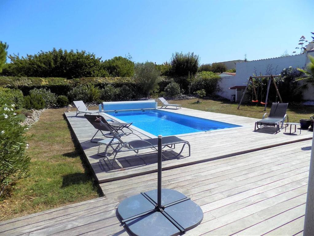 une terrasse avec une piscine et deux chaises longues dans l'établissement Meschers - MAISON RECENTE avec PISCINE PRIVATIVE dans un quartier très calme, à Meschers-sur-Gironde