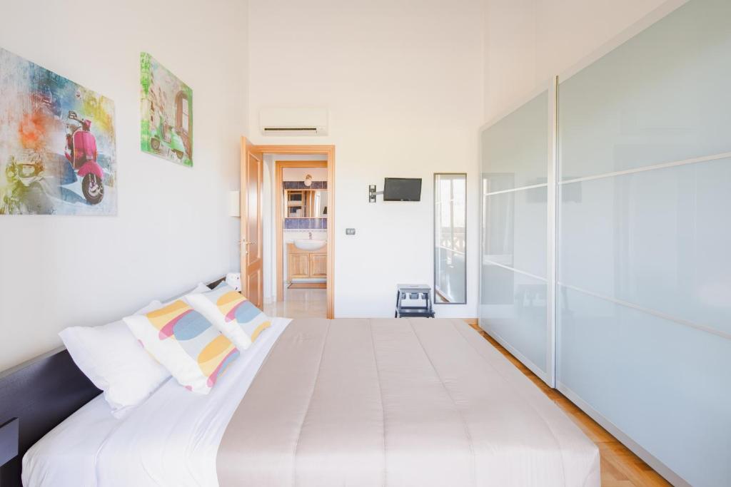 sypialnia z dużym białym łóżkiem w pokoju w obiekcie EUR Moravia Attico panoramico con terrazzo, fino a 5 ospiti w Rzymie