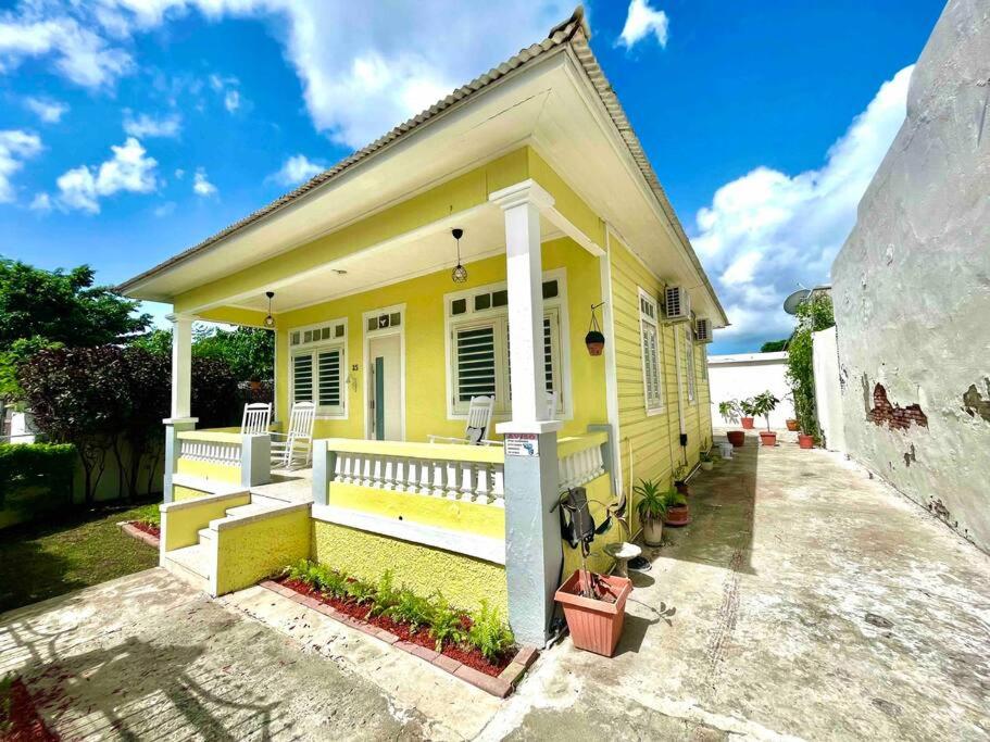 a small yellow house with a porch and avisor at New! Antique House at Ponce in Ponce