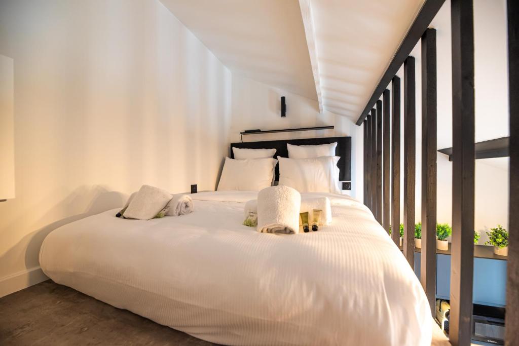 - une chambre avec un grand lit blanc et des oreillers blancs dans l'établissement Lovely Nest in Paris, à Paris